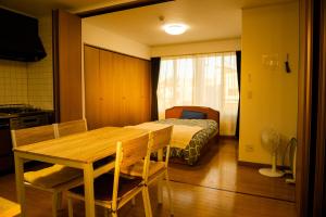 Pokój ze stołem i łóżkiem oraz sypialnią w obiekcie Hakodate cozy house w/parking w mieście Hakodate