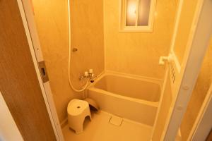a small bathroom with a tub and a toilet at Hakodate cozy house w/parking in Hakodate