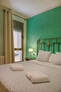 a bedroom with a large bed with a green wall at Rosa Street Apartment in Girona