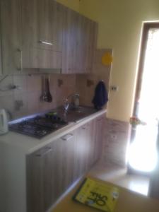- une cuisine avec des placards en bois, un évier et une cuisinière dans l'établissement SCALEA - RIVIERA DEI CEDRI, à Scalea
