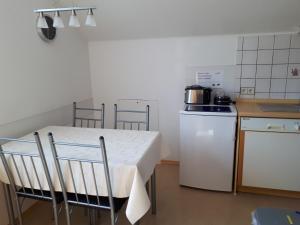 a kitchen with a white table and a white refrigerator at Ferienwohnung Rheinzabern in Rheinzabern