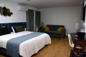 una camera d'albergo con letto e divano di Retrato da Memória-Casa de Campo a Ferreira do Alentejo