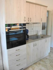 a kitchen with white cabinets and a black oven at Haus am Zemminsee in Groß Köris