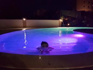 un niño nadando en una piscina por la noche en Villa Clematis, en Trogir