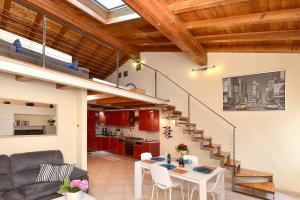 a living room with a dining table and a staircase at Antiche Rive Holidays Apartments in Salò