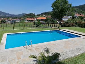 a large blue swimming pool in a yard at Casa Real in Barcelos