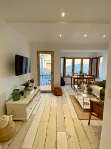 sala de estar con suelo de madera y TV en Apartaments Chenin Blanc-Priorat-, en Cornudella