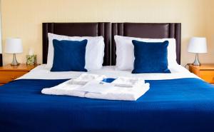 a large bed with blue sheets and blue pillows at Braemar in Shanklin