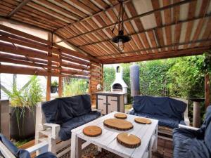 a patio with a white table and blue couches at Pokoje Malgo Ustka in Ustka