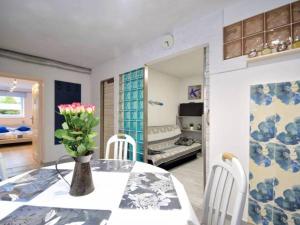 a dining room with a table with a vase of flowers on it at Pokoje Malgo Ustka in Ustka