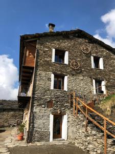 an old stone building with a clock on it at B & B La Guiette in Casteldelfino