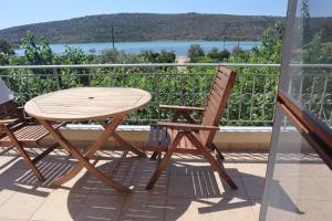 - Balcón con mesa de madera y 2 sillas en MYRTO VIVARI, en Vivari