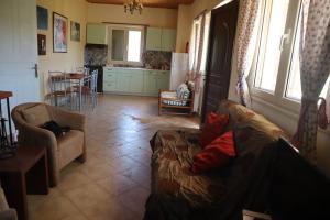 een woonkamer met een bank en een tafel en een keuken bij MYRTO VIVARI in Vivari