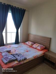 a bedroom with a bed with blue curtains and a window at كريستال لاجونز بورتو جولف الساحل الشمالي in El Alamein