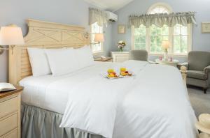 1 dormitorio con 1 cama grande y 2 vasos de zumo de naranja en Old Harbor Inn en Chatham