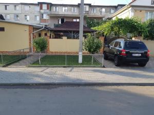 un coche aparcado en un aparcamiento al lado de un edificio en Casa Ala en Cahul