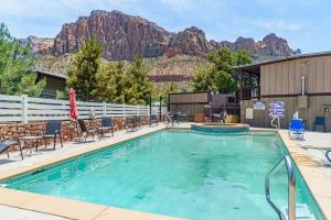 a swimming pool with a mountain in the background at Pioneer Lodge Zion National Park-Springdale in Springdale