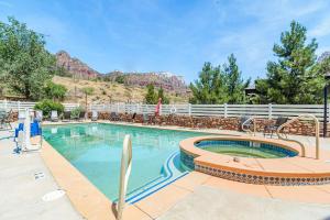 una piscina con una montaña en el fondo en Pioneer Lodge Zion National Park-Springdale, en Springdale