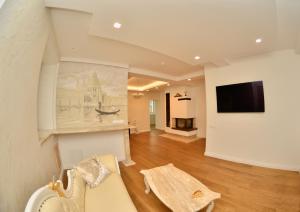 a living room with a couch and a tv on a wall at Vila Venecija in Palanga