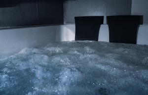 a bed in a bath tub filled with water at Jacuzzi Glass-House Central Station in Kraków