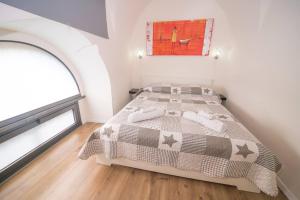 a bedroom with a bed with a comforter and a window at Central Station House Virginia in Catania