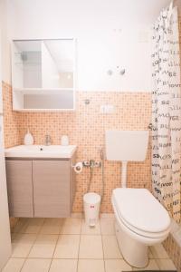 a bathroom with a toilet and a sink and a shower curtain at Central Station House Virginia in Catania