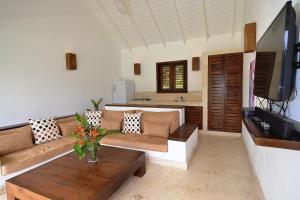 ein Wohnzimmer mit einem Sofa und einem TV in der Unterkunft Las Terrenas Front Beach And Garden Villa in Las Terrenas