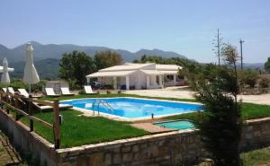 a swimming pool in front of a house at Elli Beach Apartments and Studios in Almiros Beach