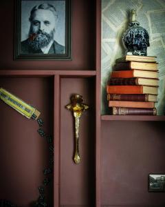 a shelf with books and a portrait of a man at The Bath Hotel in Lynmouth