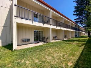 un grand bâtiment avec une pelouse devant lui dans l'établissement Sisters Inn & Suites, à Sisters