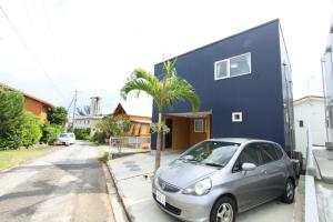 a car parked in front of a blue house at Comfort Villa V(five) in Inbu
