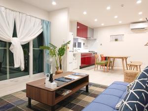 ein Wohnzimmer mit einem blauen Sofa und einem Tisch in der Unterkunft Comfort Villa V(five) in Inbu