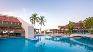 a pool at a resort with chairs and palm trees at Park Royal Beach Ixtapa - All Inclusive in Ixtapa