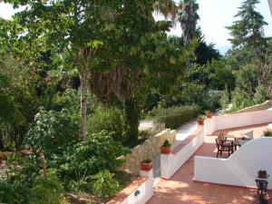 a patio with tables and chairs in a garden at Quinta Verde Sintra - Casa de Campo in Sintra