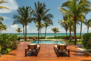 a resort with a swimming pool and palm trees at Andaz Mayakoba All Inclusive Package in Playa del Carmen