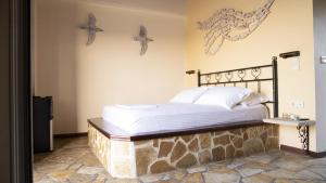 Cama en habitación con estrella de mar en la pared en Margina Residence Hotel, en Gáios