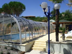 une piscine dans une serre en verre à côté d'un bâtiment dans l'établissement Locations de Vacances Les Flachères (Dieulefit), à Dieulefit