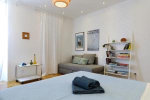 a white bedroom with a bed and a couch at Lovely Rita's Sibenik - apartment city center in Šibenik