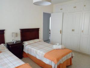 a bedroom with two beds and white cabinets at EL PUERTO CENTRO OCIO in El Puerto de Santa María
