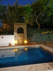a swimming pool with a gate in a backyard at night at Entre pinos y playa in Matalascañas
