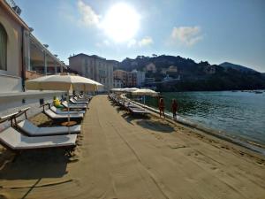 a beach area with chairs, tables and umbrellas at Hotel Miramare & Spa in Sestri Levante