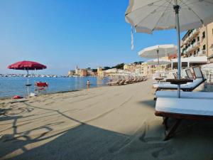a beach with chairs and umbrellas and the ocean at Hotel Miramare & Spa in Sestri Levante