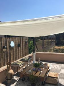 a patio with a white canopy and a table and chairs at L'insolite et médièvale Tour Yselda in Saint-Pourçain-sur-Sioule