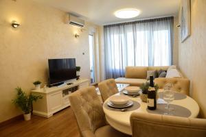 a living room with a table and a couch at Tesla 70 Apartment with secure parking In the garage in Novi Sad