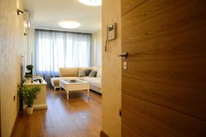 a living room with a couch and a table at Tesla 70 Apartment with secure parking In the garage in Novi Sad