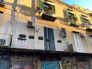 a building with potted plants on the side of it at Caprese Experience - Light Blu Apt - Dante in Naples