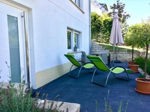 eine Terrasse mit 2 Stühlen und einem Sonnenschirm in der Unterkunft Ferienwohnung Ströbele in Müllheim