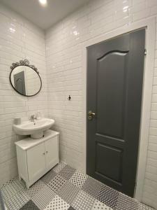 La salle de bains est pourvue d'un lavabo et d'une porte noire. dans l'établissement habitat Sea View Apartment Varna, à Varna