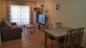 un salon avec une table, un canapé et une télévision dans l'établissement Al Andalus Thalassa III VERARENTAL-COM, à Vera