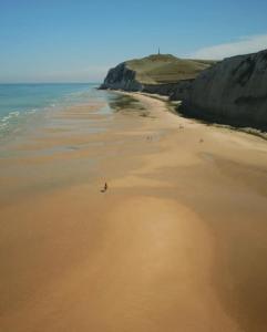 una playa con un grupo de personas caminando por la arena en Le Clos de l'Angley Gîtes et Écurie en Caffiers